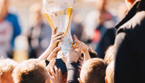 Sportler, die einen Pokal hochhalten